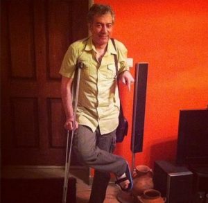 محمدرضا هدایتی با عصا و پایش در گچ