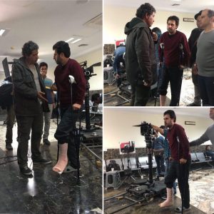 هومن حاجی عبداللهی با عصا سر صحنه فیلم برداری