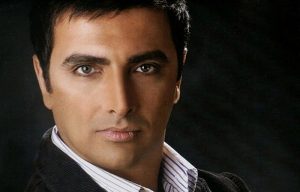 پرتره امین زندگانی با کت مشکی و پیرهن راه راه سفید