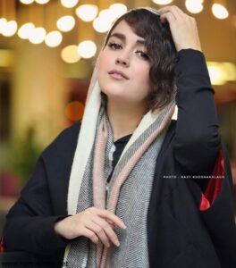 افسانه پاکرو با پالتو مشکی و شال بافت سفید