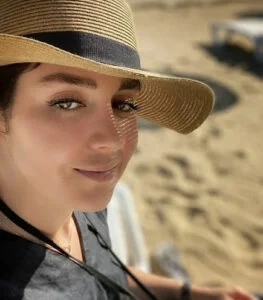 افسانه پاکرو با لباس مشکی و کلاه در کنار ساحل